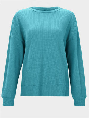 Waffle knit crewneck top in pastel blue with relaxed fit and long sleeves.