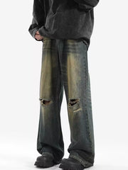Men's distressed wide-leg jeans with ripped knees and vintage wash.