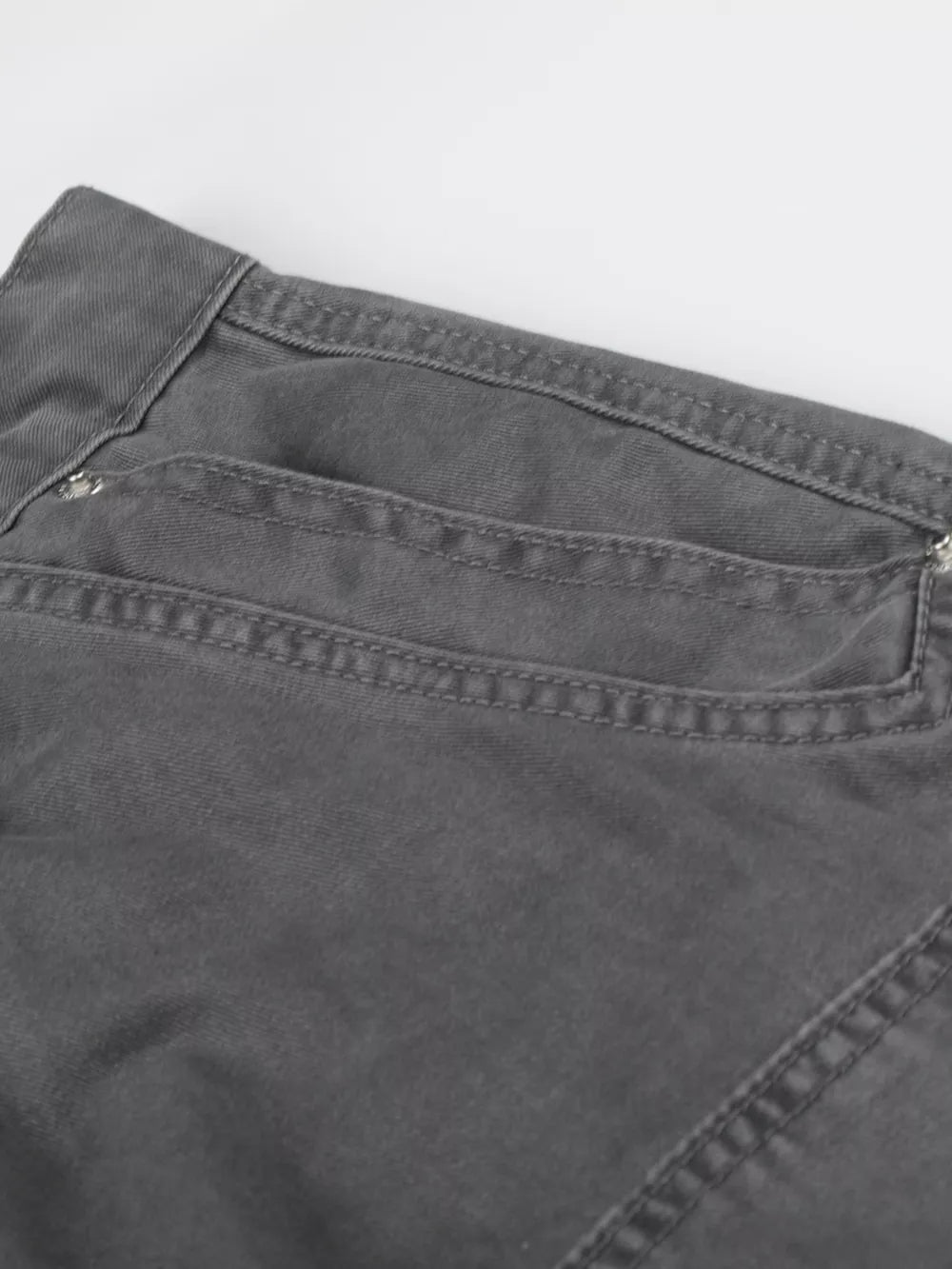 Men's grey cotton cargo capris with button closure and detailed stitching.