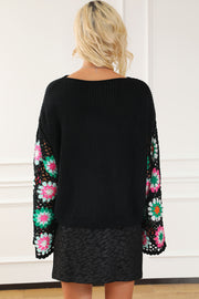 Black knit pullover sweater with colorful crochet granny square sleeves and a boat neck.