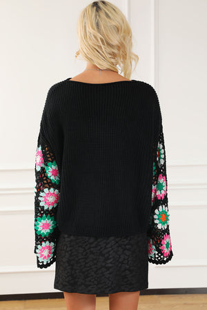 Black knit pullover sweater with colorful crochet granny square sleeves and a boat neck.