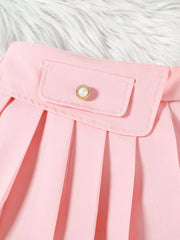 Pink baby skirt with pleated detail and decorative pearl button pocket.