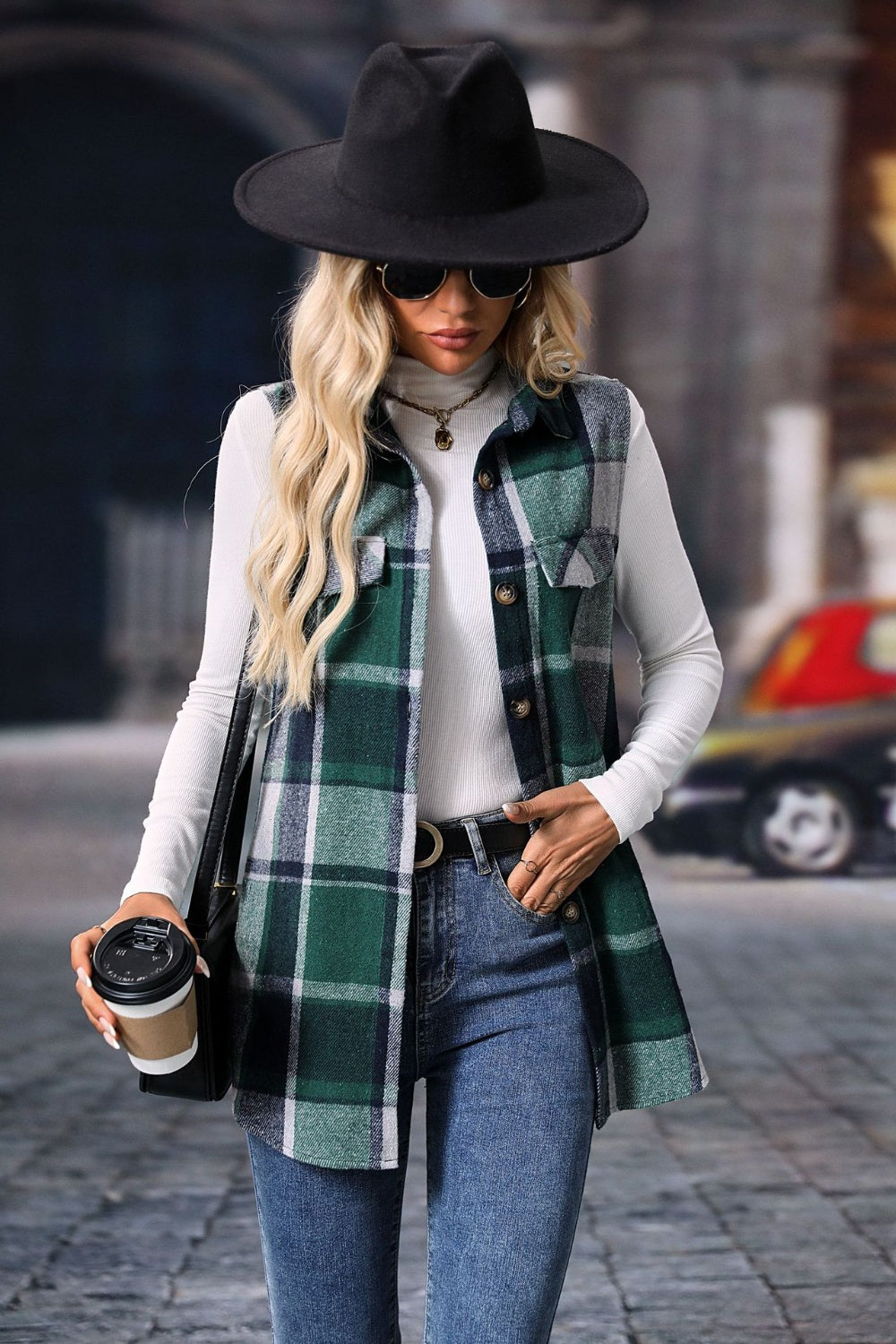 Plaid utility vest in dark green with patch pockets and button closure, worn over a white turtleneck.