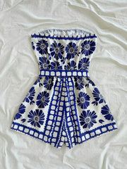 Blue floral strapless maternity romper with tie-waist and scalloped hem.