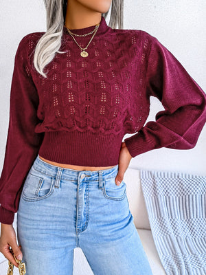 Burgundy openwork knit sweater with puff sleeves and mock neck.