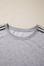 Grey relaxed t-shirt with black and white shoulder stripes and crew neck.