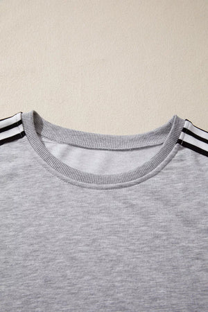 Grey relaxed t-shirt with black and white shoulder stripes and crew neck.