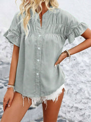 Light gray button-up blouse with gathered yoke and ruffle sleeves.