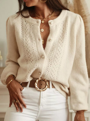 Cream knit button-up cardigan with open panels and puff sleeves.