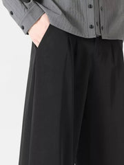 Men's black wide leg dress pants with pleats and side pockets.