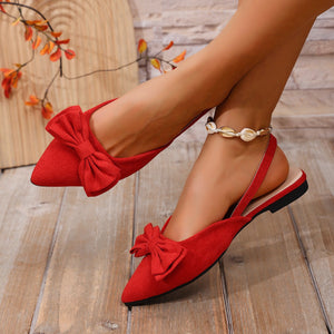 Red bow accent slingback slip-on flats with pointed toe and ankle strap.