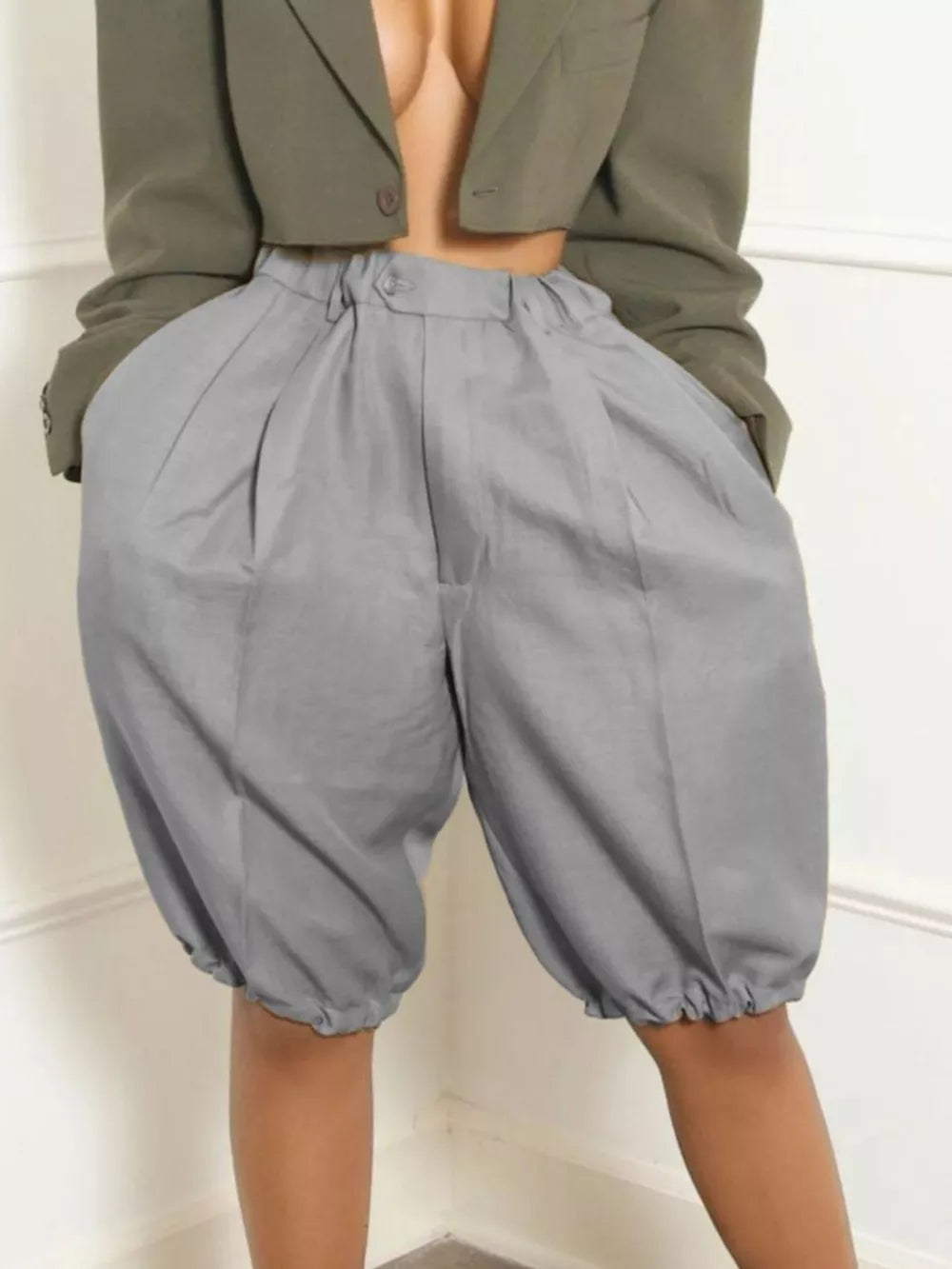 Gray pleated high-waisted shorts with drawstring hem and balloon silhouette.