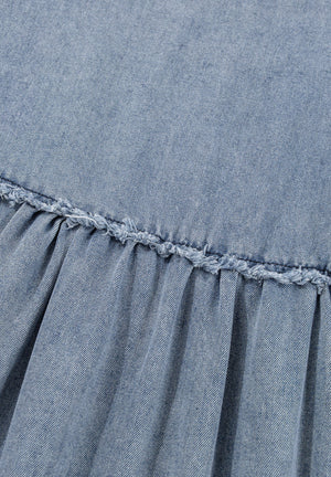 Medium wash denim mini dress with gathered waist and frayed ruffle detail.