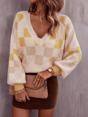 Geometric V-neck knit sweater in cream and light yellow checkerboard pattern with puff sleeves.