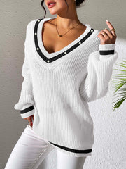 White ribbed knit V-neck sweater with pearl trim and black stripe details on neckline and cuffs.