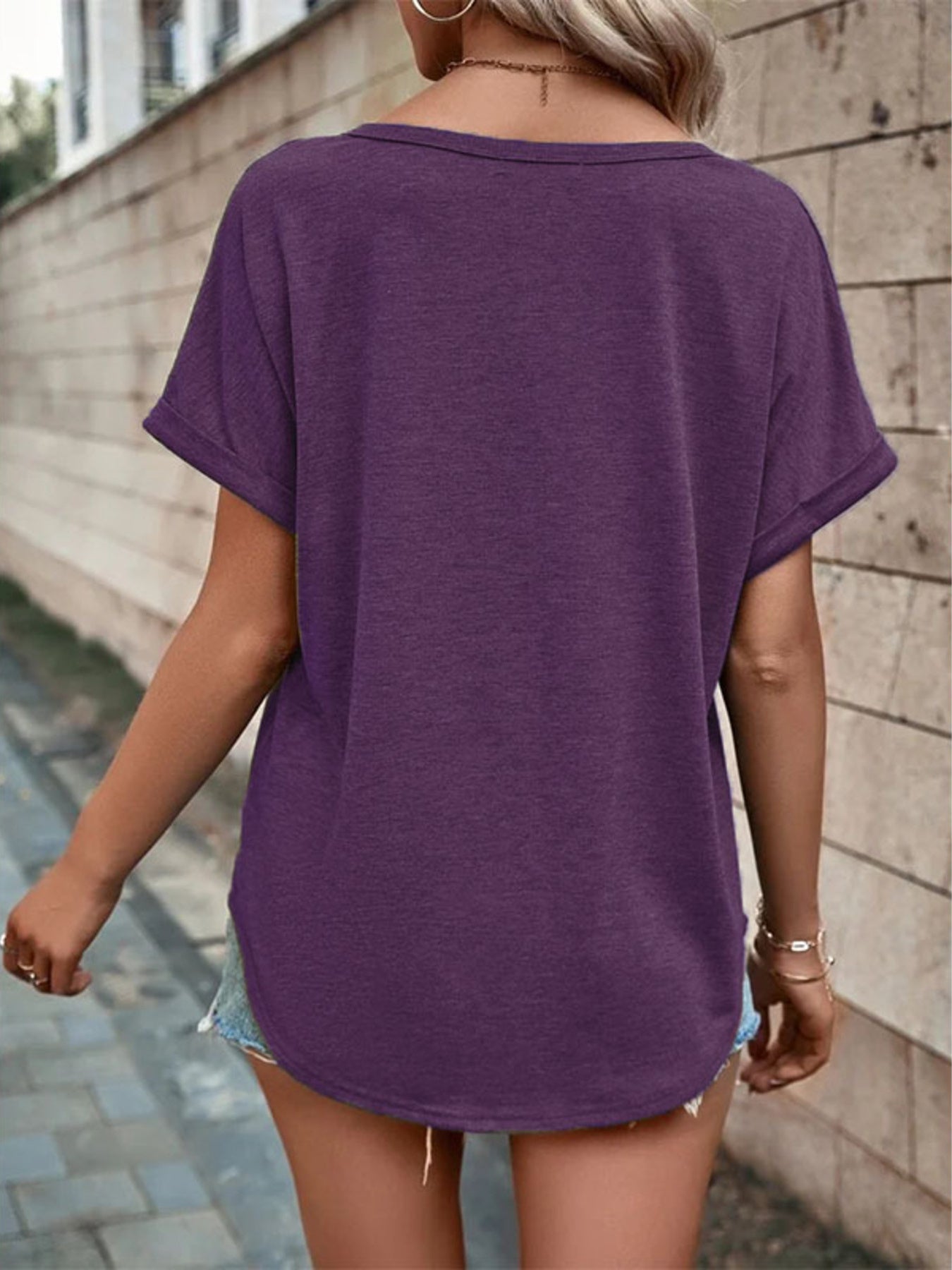 Purple short sleeve V-neck t-shirt with rolled cuffs and a curved hem.