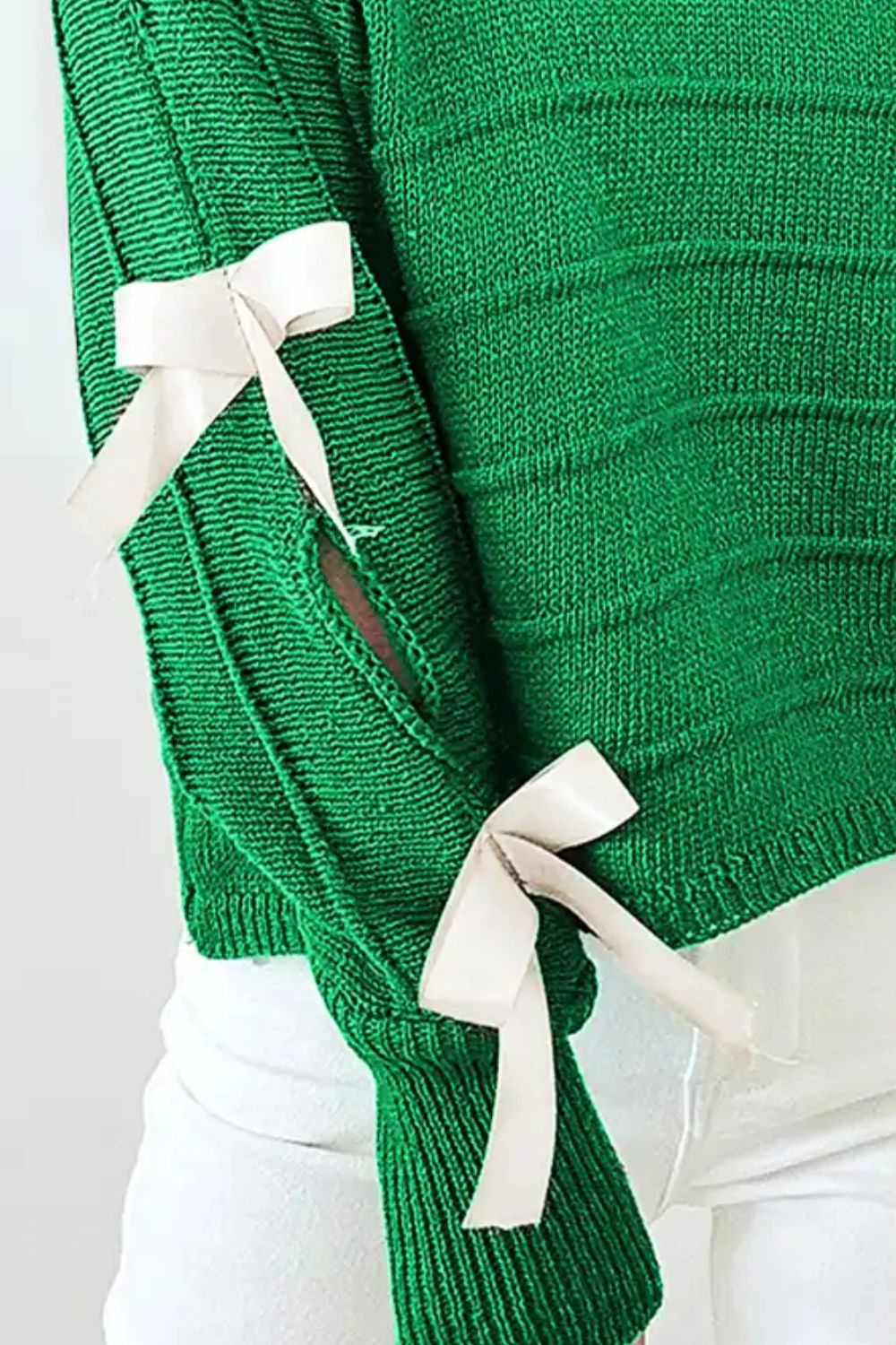 Dark green ribbed knit sweater with bow sleeve detail and cut-out accents.