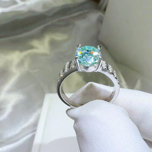Aquamarine halo oval ring with diamond accents on a silver band.