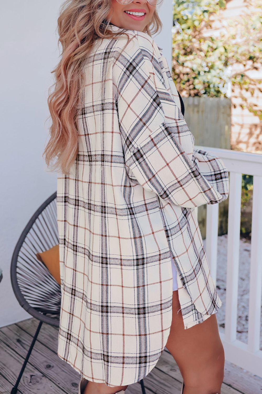 Oversized white plaid shacket with a relaxed fit and button cuffs, styled open over a black top.