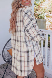 Oversized white plaid shacket with a relaxed fit and button cuffs, styled open over a black top.