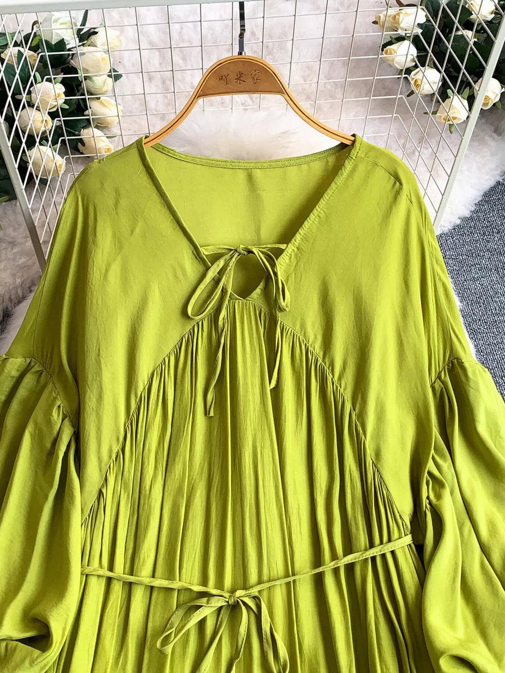 Light green bohemian maxi dress with balloon sleeves, V-neck tie detail, and cinched waist.