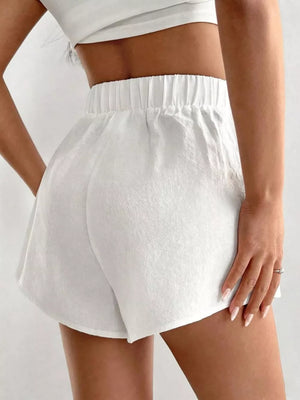 White cotton chino shorts with elastic waistband and relaxed fit.