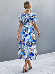 Blue abstract print midi dress with tie waist and short sleeves, shown from the back.