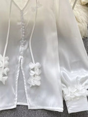 White sheer button-down shirt with delicate floral appliqué and pearl buttons.