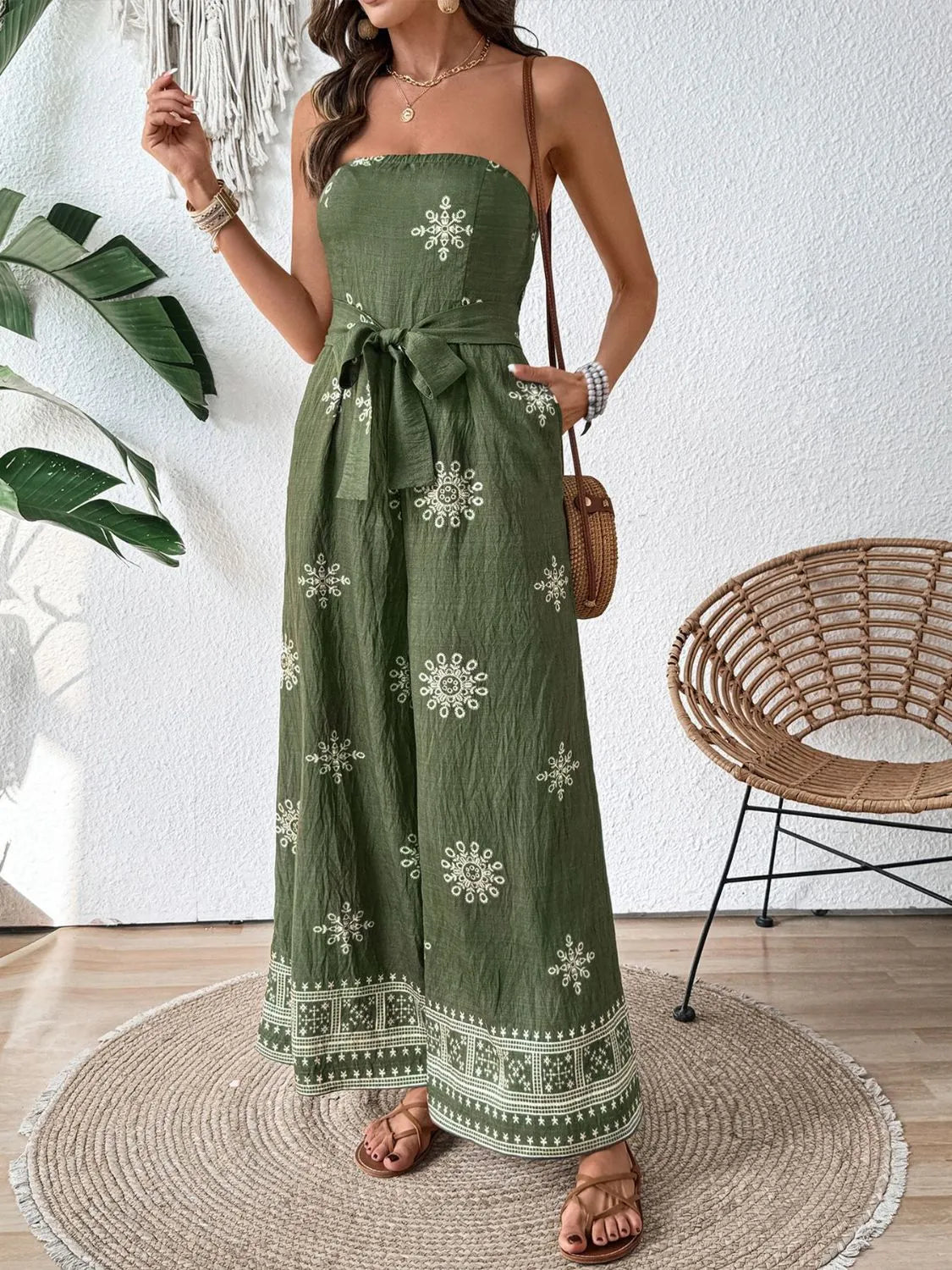 Bandeau jumpsuit in matcha green with white embroidery and wide legs.