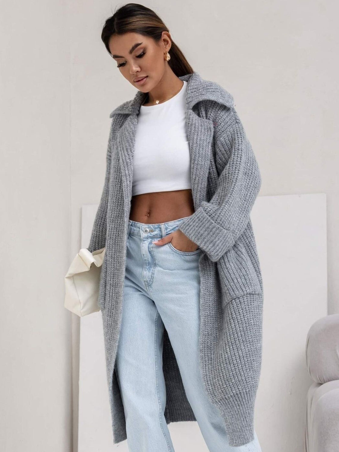 Gray oversized knit cardigan with lapel neckline and cuffed sleeves.