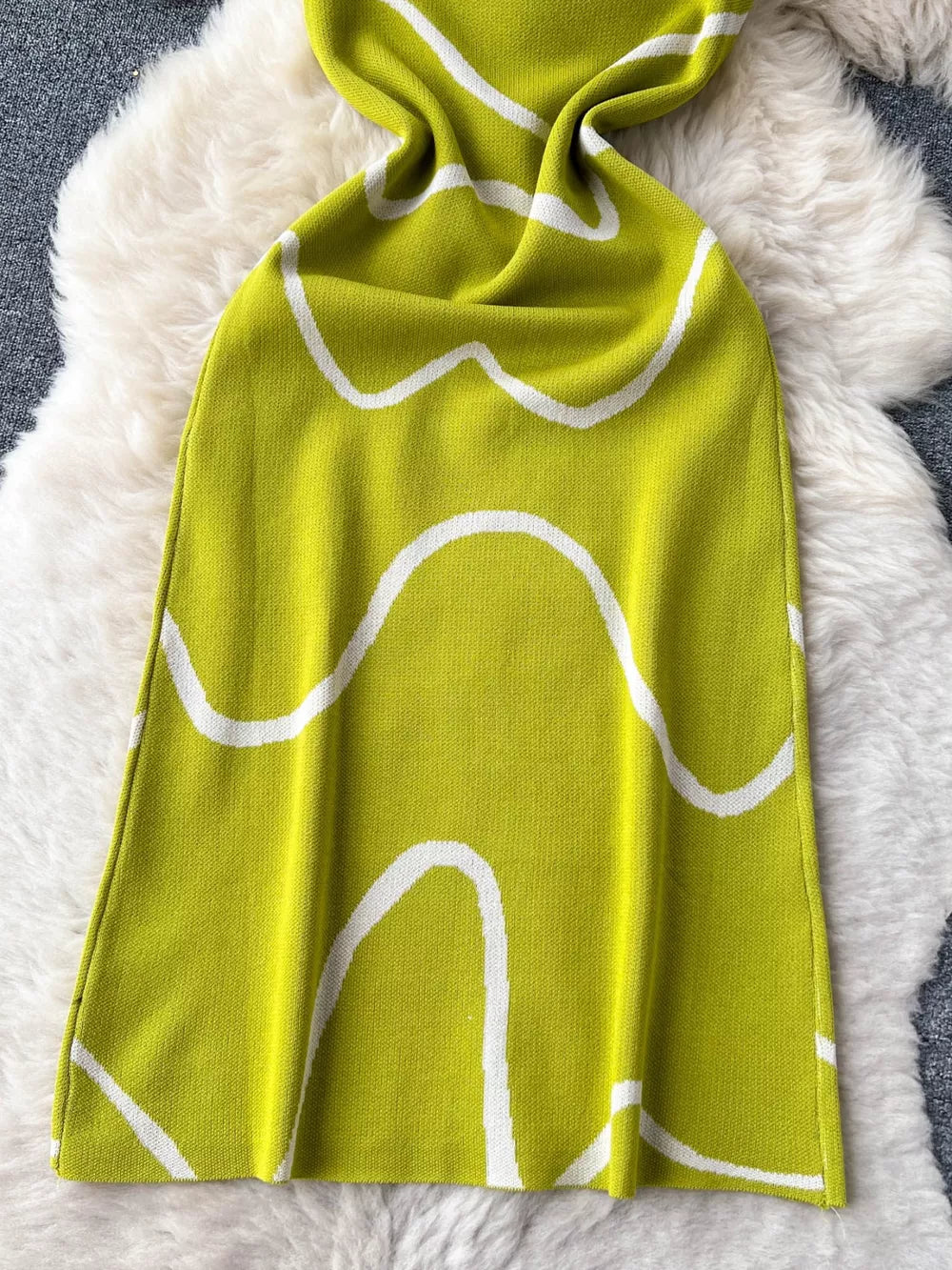 Green wavy knit midi dress with spaghetti straps and abstract white pattern