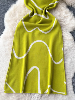 Green wavy knit midi dress with spaghetti straps and abstract white pattern