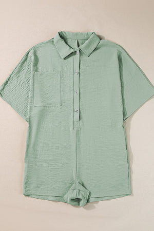 Sage oversized shirt romper with short sleeves, button front, chest pocket and cuffed shorts.