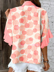 Polka dot blouse with ruffle sleeves and a collared neckline.