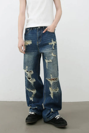 Oversized ripped denim jeans in medium wash with a wide-leg silhouette and distressed details.