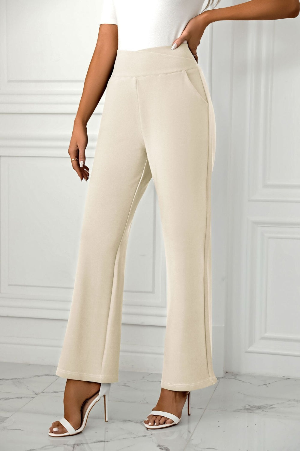 Beige wide-leg trousers with a sculpted waist and side pockets.