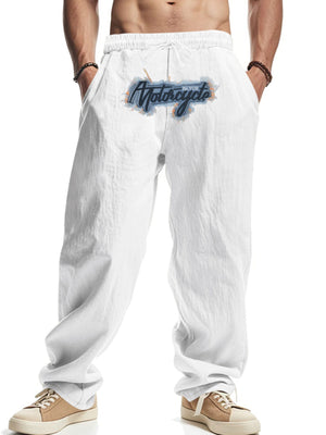 White drawstring sweatpants with a blue and orange "Motorcycle" graphic on the left thigh.