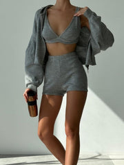 Gray ribbed knit hoodie, bralette, and shorts set with long sleeves and a drawstring hood.