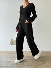 Black ribbed knit loungewear set with flared sleeves and wide-leg pants with pockets.