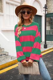 Oversized knit sweater with bold pink and green stripes, balloon sleeves, and crew neck.