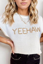 White knit sweater top with embroidered Yeehaw text and stitch trim detail.