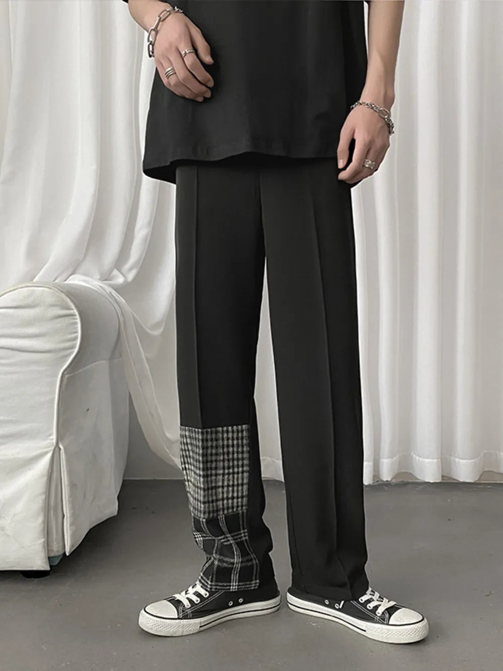 Men's black straight-leg chinos with plaid patchwork detail on the lower leg.