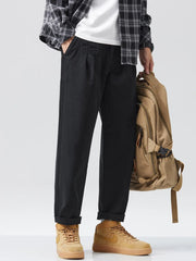 Men's black relaxed fit sweatpants with pockets and cuffed ankles.