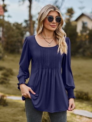 Navy peplum sleeve top with gathered yoke and smocked cuffs.