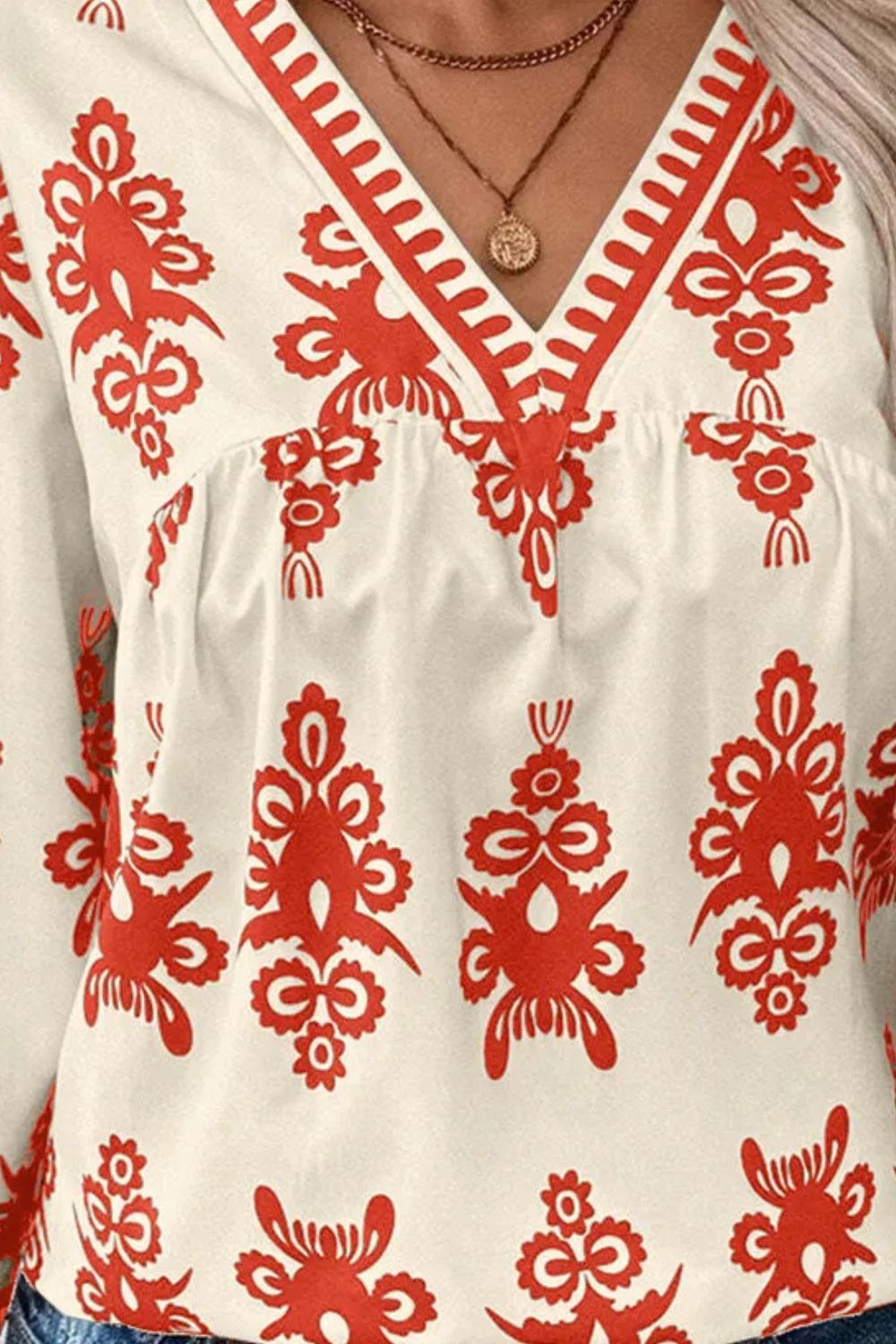 Ivory v-neck blouse with red embroidered pattern and contrast trim