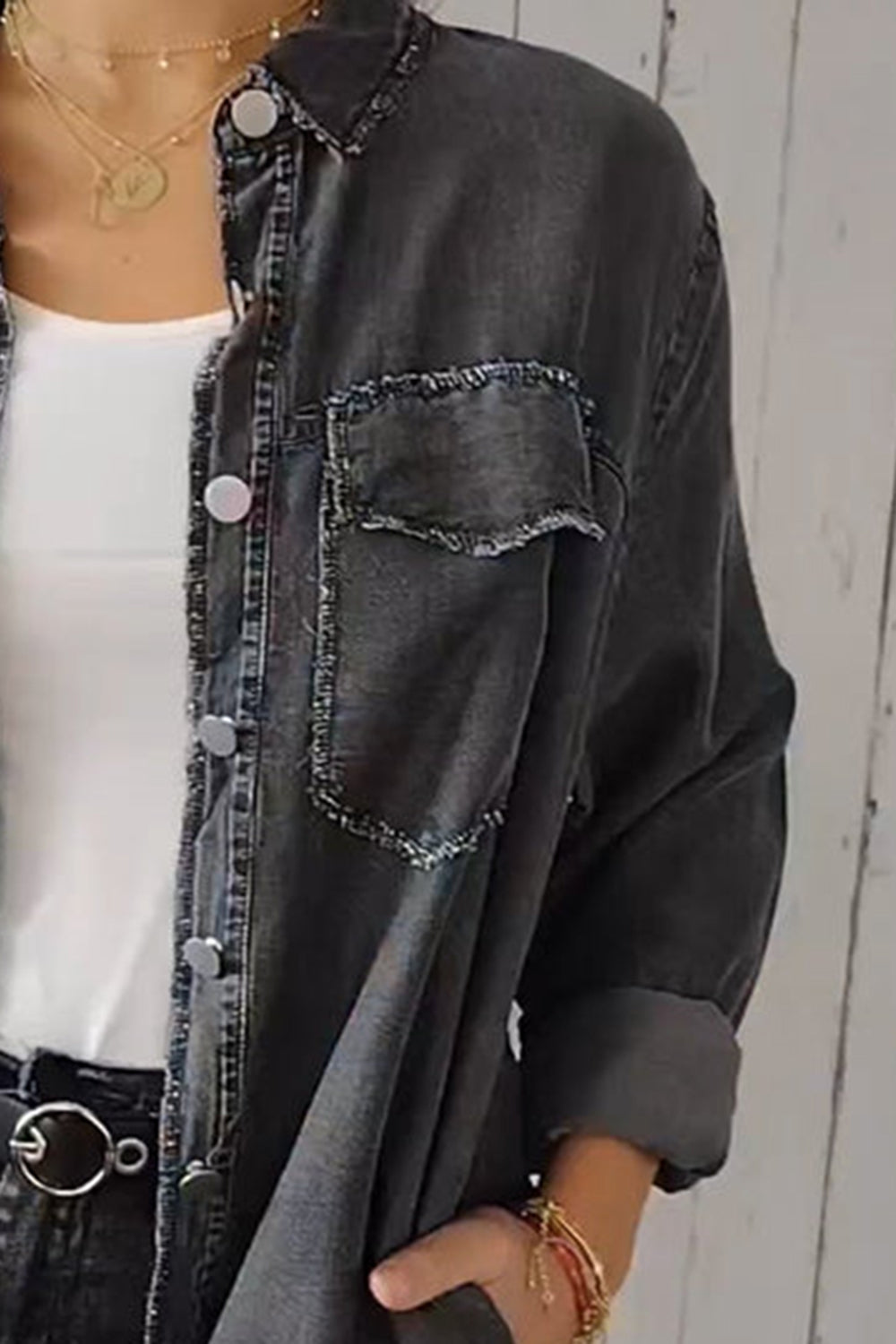 Dark gray oversized denim shirt jacket with frayed pocket details and buttoned front.