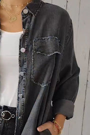 Dark gray oversized denim shirt jacket with frayed pocket details and buttoned front.
