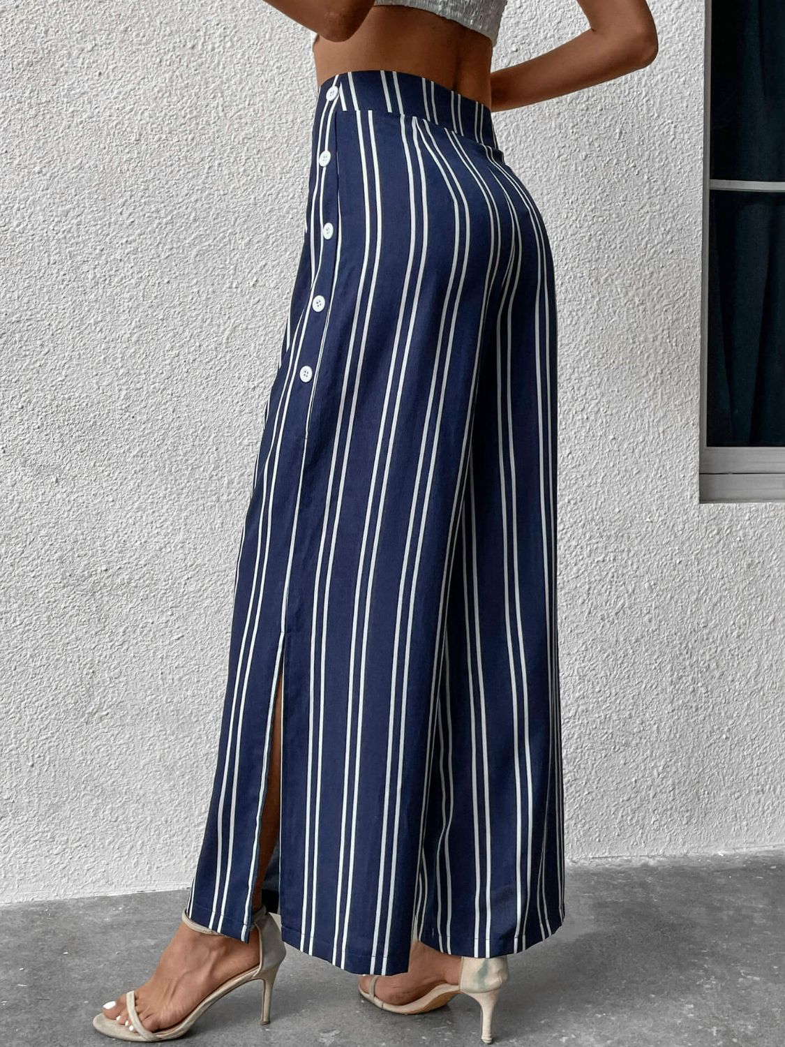 Dark blue vertical stripe palazzo trousers with side slit and button detail.