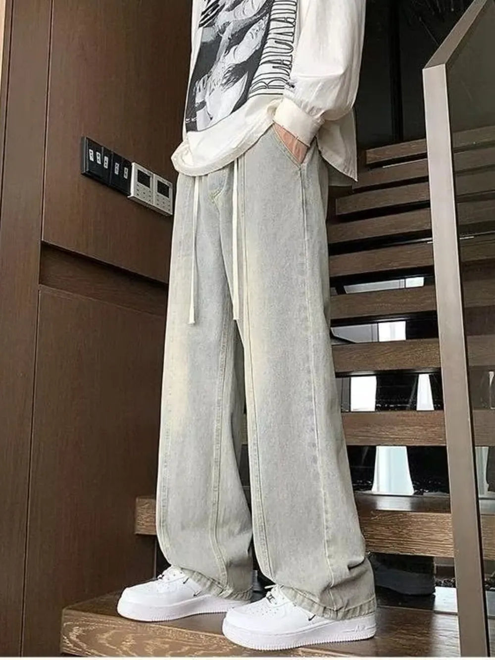 Men's light gray oversized fit jeans with drawstring waist and distressed details.
