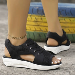 Black lace-up wedge sandals with mesh details and white soles.